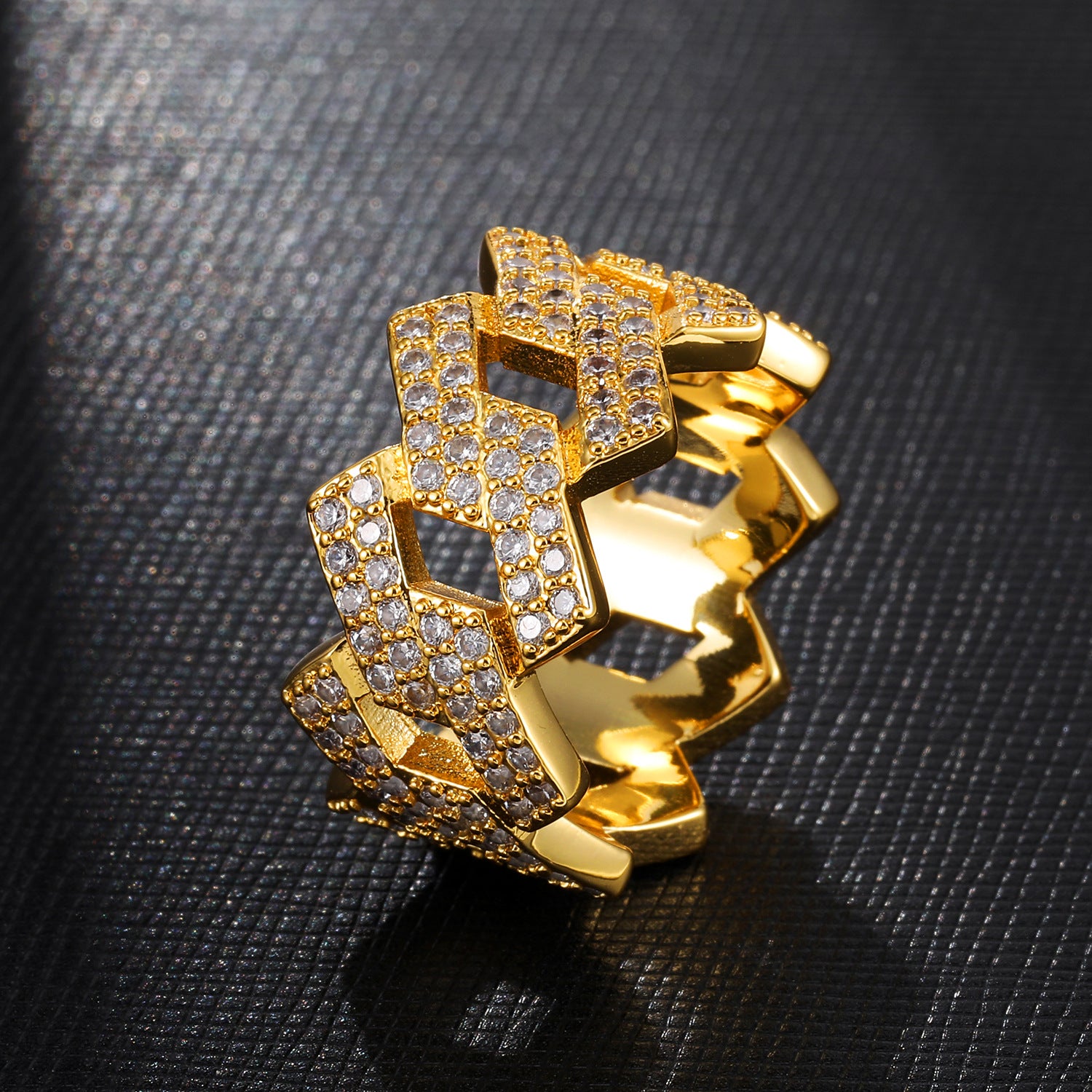 a gold ring with diamonds on a black surface