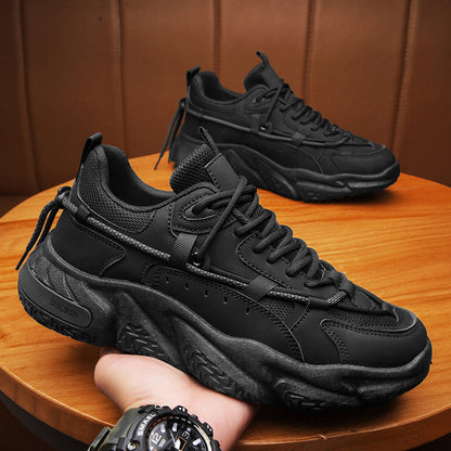 a person's hand holding a black sneaker on top of a wooden table