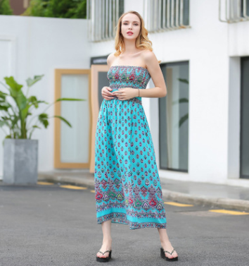 a woman standing in a parking lot wearing a strapless dress