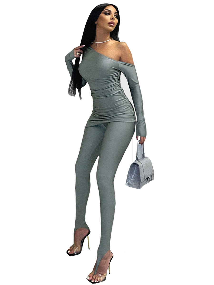 a woman in a grey bodysuit holding a purse