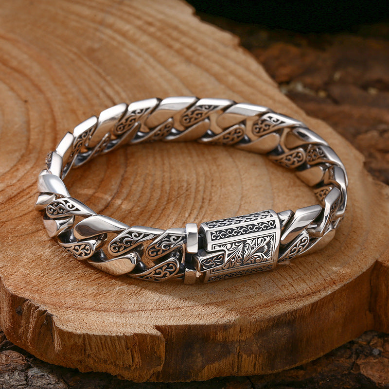 a close up of a silver bracelet on a wooden surface