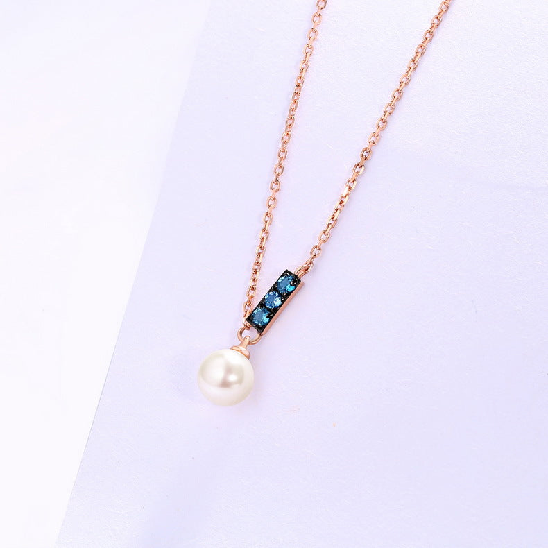 a necklace with a pearl and blue stones
