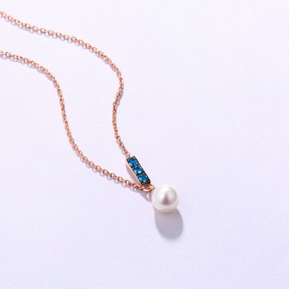 a necklace with a pearl and a blue stone