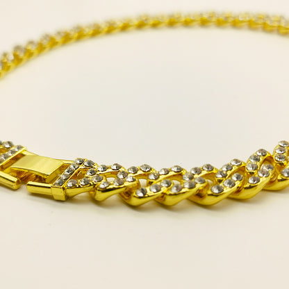 a close up of a gold chain on a white surface