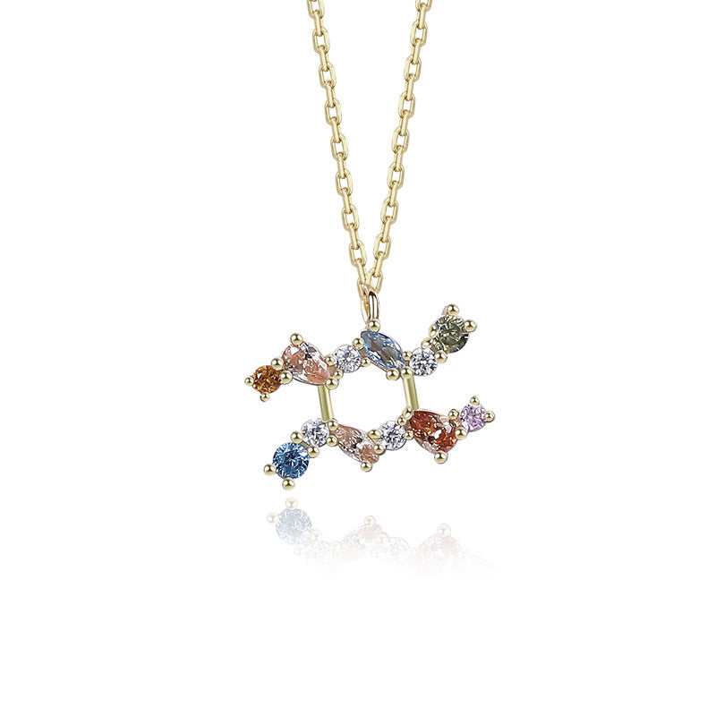 a gold necklace with multicolored stones on a chain