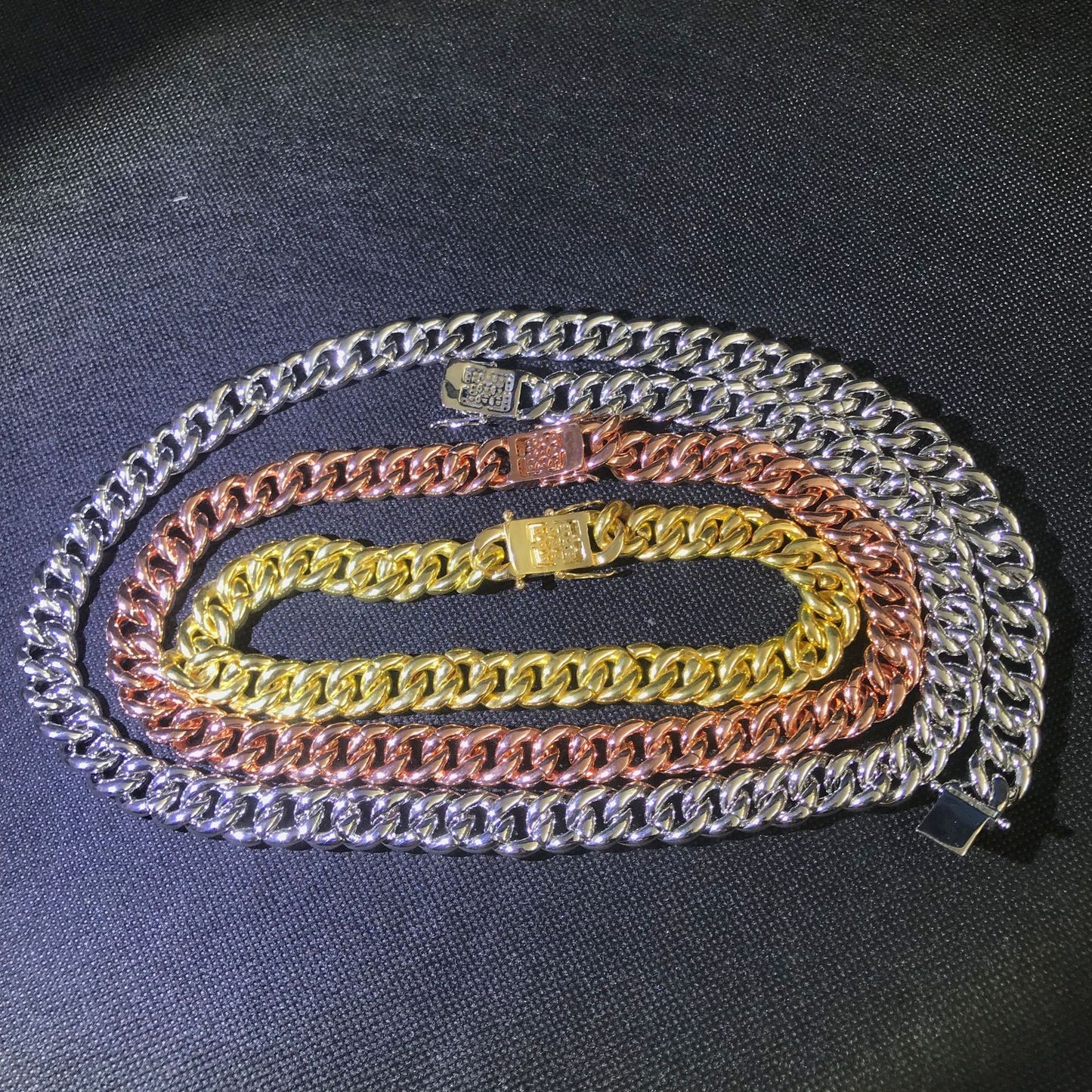 three different colored chains on a black surface