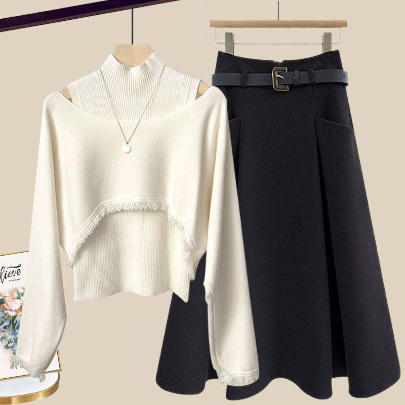 a white sweater and black skirt hanging on a rack