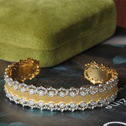 a close up of a pair of gold and diamond bracelets