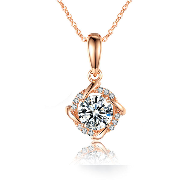 a rose gold pendant with a white diamond in the center