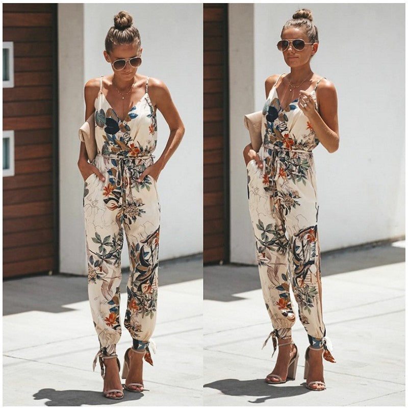 a woman standing on a sidewalk wearing a floral jumpsuit