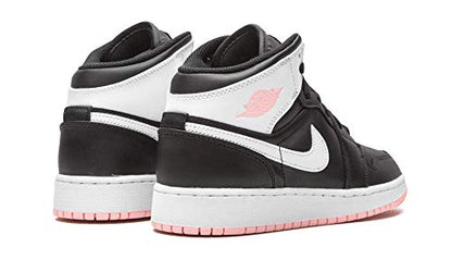 a pair of black and white sneakers with pink soles