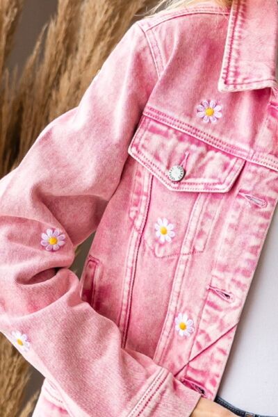 a little girl wearing a pink jean jacket