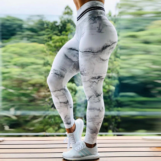 a woman in white and black leggings with trees in the background